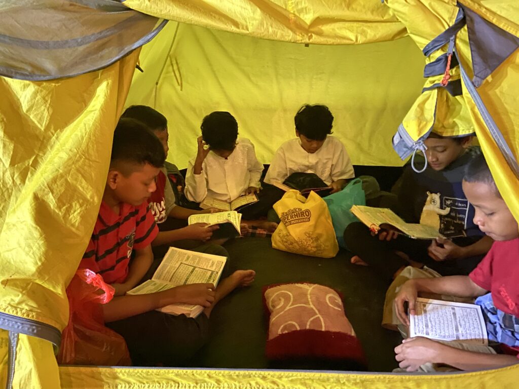 Suasana siswa MIM Karan yang sedang mengaji bersama di dalam tenda.